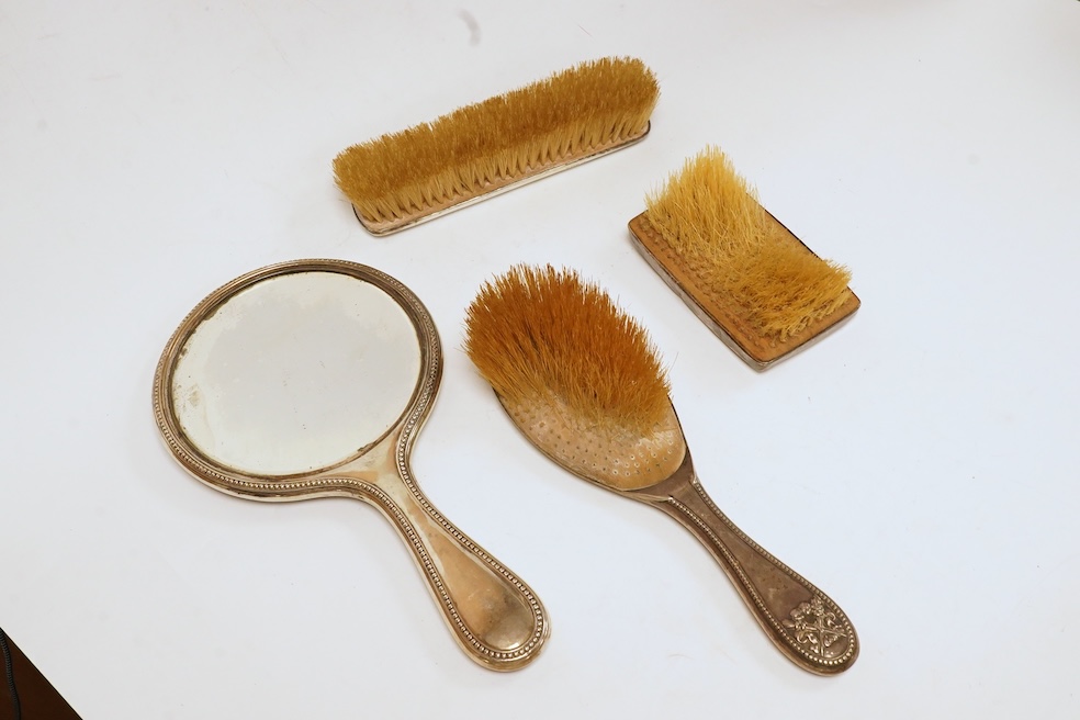 A George V three piece silver mounted three piece mirror and brush set by William Hutton & Sons Ltd and one other silver mounted hair brush. Condition - poor